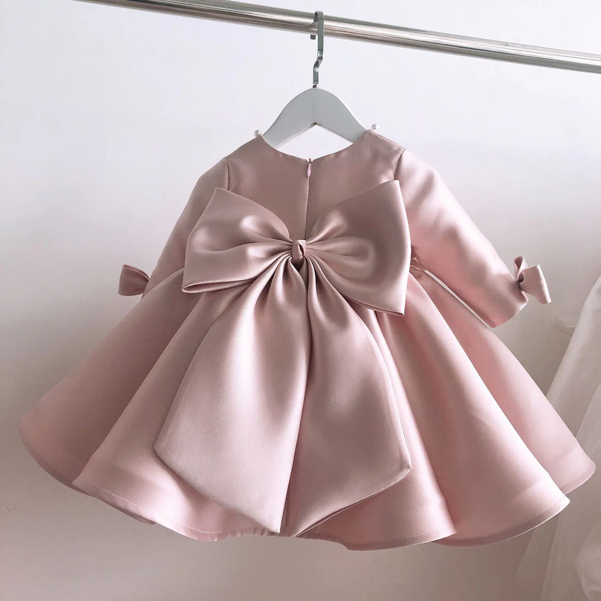 Blush satin frock with bow for a baby girl
