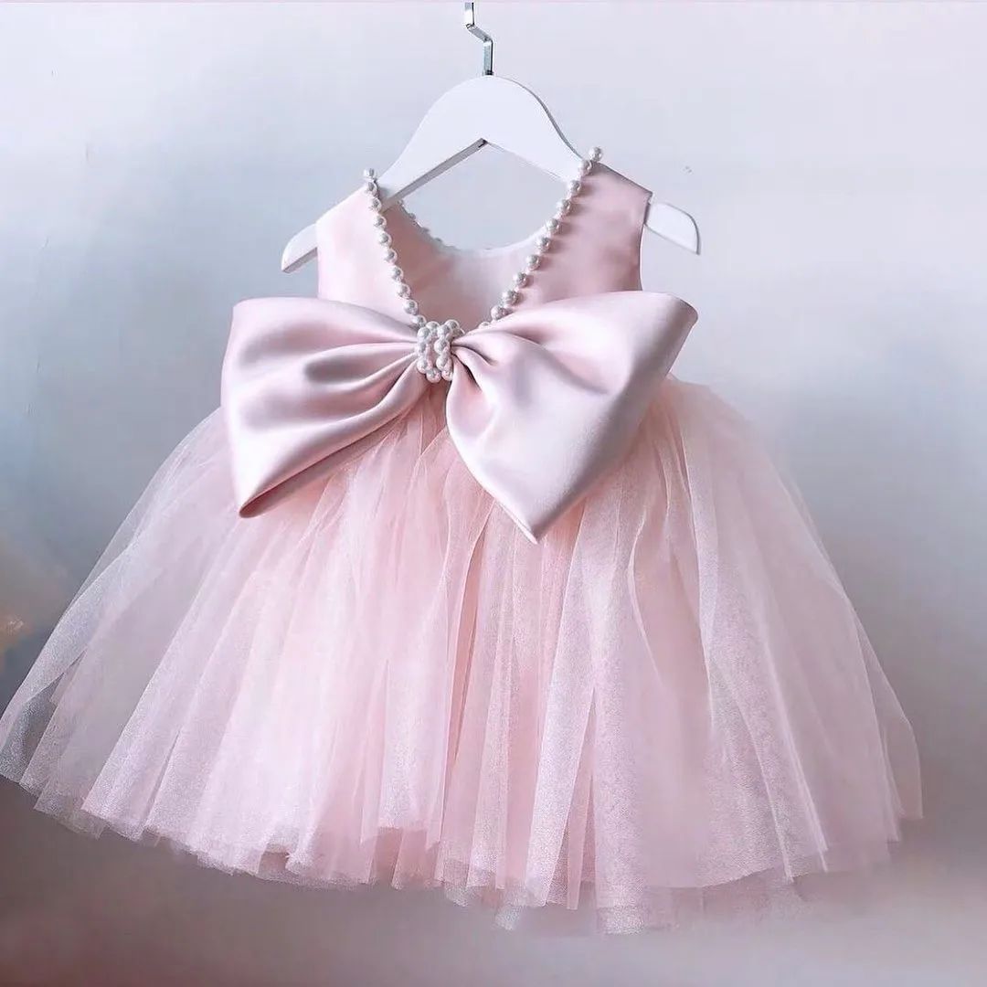 Blush pearl tulle frock with bow for a baby girl
